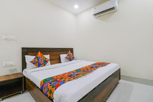 sypialnia z łóżkiem z kolorowym kocem w obiekcie FabExpress Kartikey Inn w mieście Haridwar