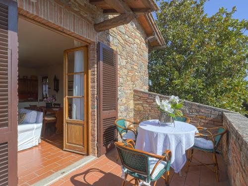 un patio con mesa y sillas en una pared de ladrillo en Apartment Casetta by Interhome en Poggibonsi