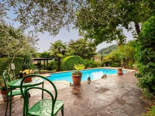 a patio with a table and chairs next to a swimming pool at Apartment Villa Margherita-2 by Interhome in Anduins