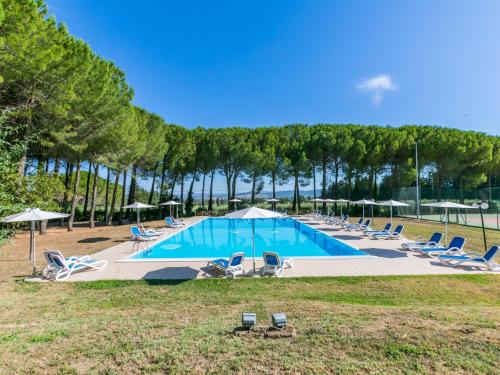 a large swimming pool with chairs and umbrellas at Holiday Home Bilocale - Ranch Hotel by Interhome in Scarlino