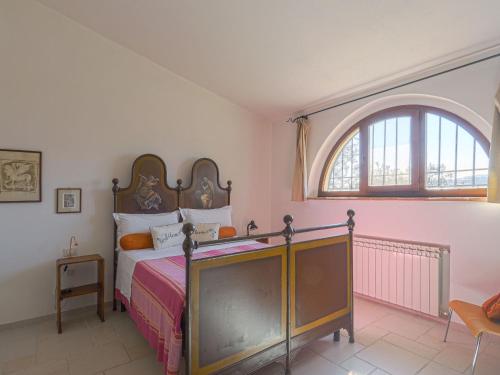 a bedroom with a bed and an arched window at Holiday Home Podere San Raffaele - Cinzia by Interhome in Poggibonsi