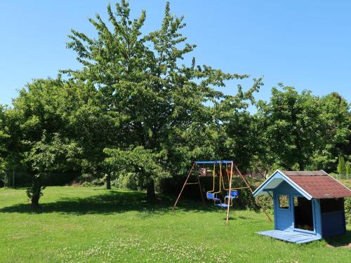 um parque infantil com um baloiço e uma casa em Apartment Petra by Interhome em Nentershausen