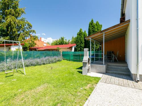 バラトンボグラールにあるHoliday Home Bercsényi by Interhomeの柵とブランコのある庭
