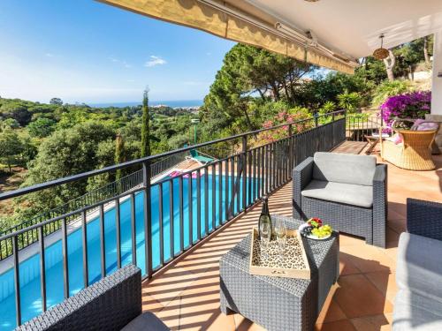 a balcony with chairs and a table and a pool at Holiday Home Balmain by Interhome in Lloret de Mar