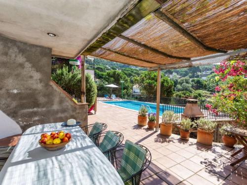 a table with a bowl of fruit on a patio at Holiday Home Balmain by Interhome in Lloret de Mar