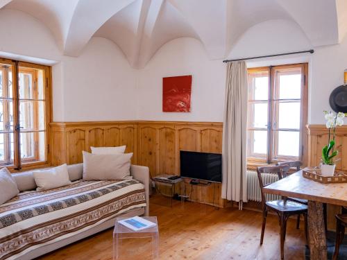 ein Wohnzimmer mit einem Sofa und einem Tisch in der Unterkunft Apartment Chesa Chascharia 1 by Interhome in Samedan