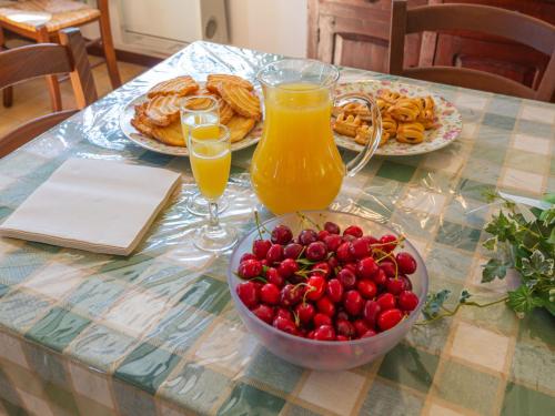 a table with a bowl of berries and orange juice at Holiday Home Fonte del Ceppo 2-2 by Interhome in Montone