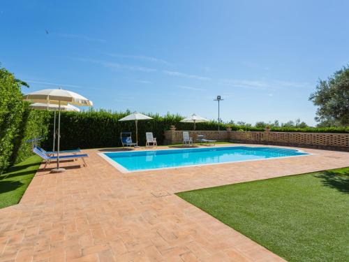 a swimming pool in a yard with an umbrella at Holiday Home Borgo Agrituristico Il Pino-1 by Interhome in Crecchio