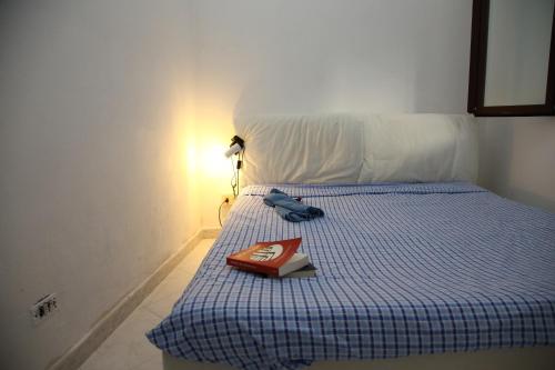 a book sitting on top of a bed with a lamp at Villini Sulla Spiaggia in Capoliveri