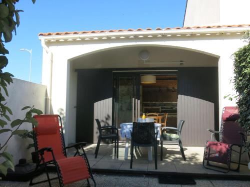 un patio avec une table et des chaises devant un bâtiment dans l'établissement Holiday Home Le Goeland Argenté by Interhome, à Les Sables-dʼOlonne