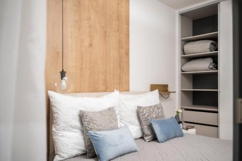 a bedroom with a bed with pillows and a closet at Napfény Resort Apartman in Balatonlelle
