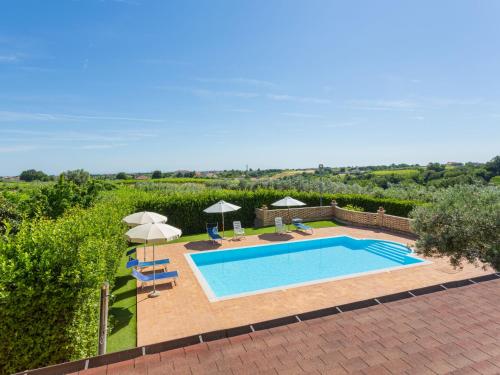 a swimming pool with umbrellas and chairs next to at Holiday Home Borgo Agrituristico Il Pino-2 by Interhome in Crecchio