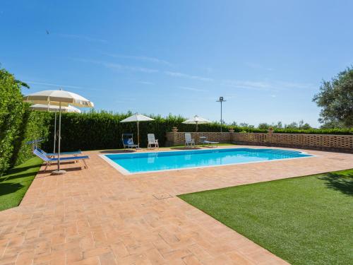 una piscina en un patio con sombrilla en Holiday Home Borgo Agrituristico Il Pino-3 by Interhome, en Crecchio