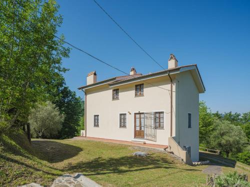 ein altes weißes Haus mit einem grünen Hof in der Unterkunft Holiday Home Buratto by Interhome in Monsagrati