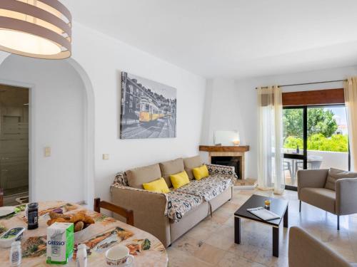 een woonkamer met een bank en een tafel bij Apartment Quinta do Torrejão by Interhome in Porches