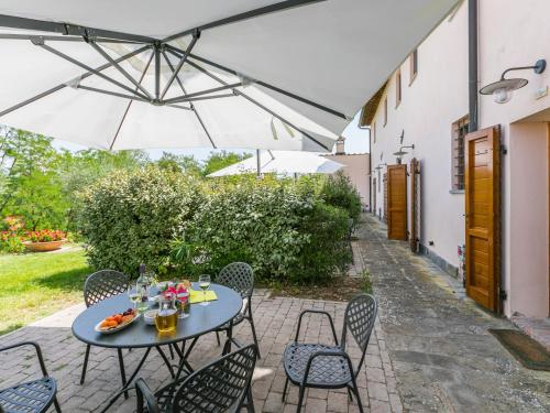 a patio with a table and chairs and an umbrella at Apartment Francigena-4 by Interhome in Castelnuovo D'elsa