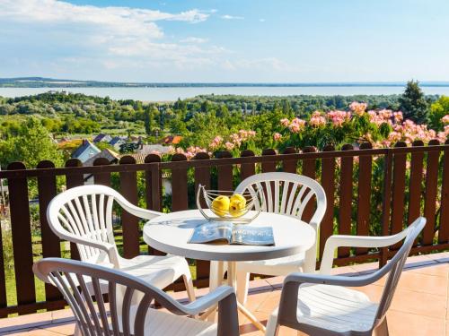 d'une table et de chaises blanches sur un balcon avec vue. dans l'établissement Holiday Home Panorama by Interhome, à Balatongyörök