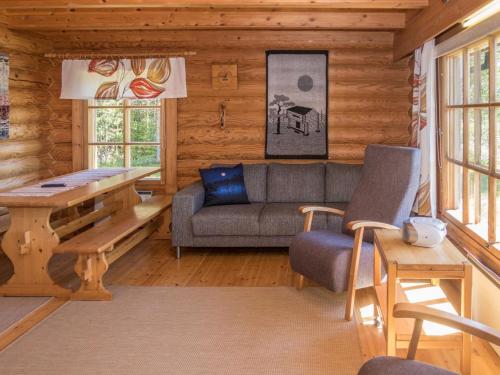 a living room with a couch and a table at Holiday Home Ruka-kitkan käki by Interhome in Säkkilänvaara