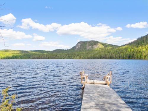 eine Bank am Ende eines Stegs an einem See in der Unterkunft Holiday Home Pöllölaakso by Interhome in Ruka