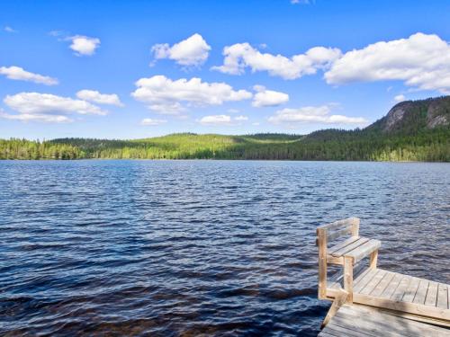 eine Holzbank auf einem Steg auf einem See in der Unterkunft Holiday Home Pöllölaakso by Interhome in Ruka