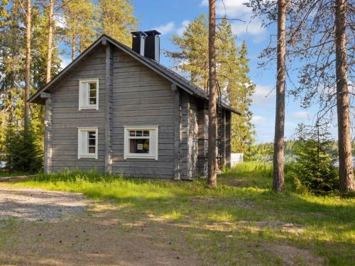 une vieille maison dans les bois à côté d'un chemin de terre dans l'établissement Holiday Home Joulupukin mökki by Interhome, à Sonka