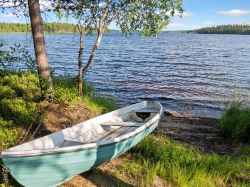 a boat sitting on the shore of a lake at Holiday Home Joulupukin mökki by Interhome in Sonka