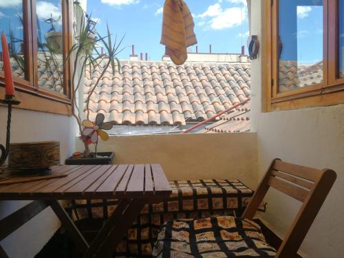 Dúplex con Garaje en Malasaña في مدريد: طاولة وكرسي في غرفة مع نافذة