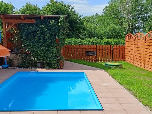 a swimming pool in a backyard with a wooden fence at Holiday Home Olešná by Interhome in Olešná