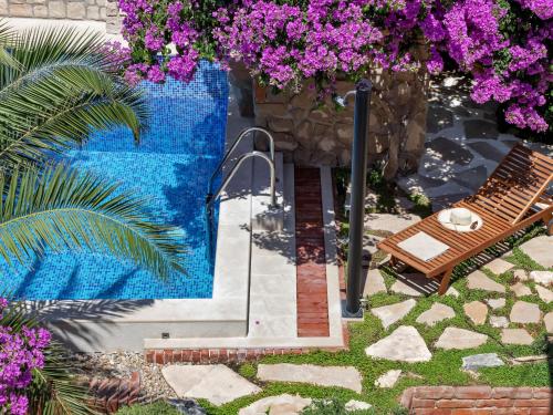 a swimming pool with a bench and purple flowers at Holiday Home Marijan by Interhome in Sutivan