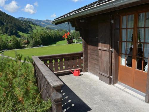 ein kleines Gebäude mit einem roten Eimer auf einer Veranda in der Unterkunft Apartment Arduus by Interhome in Gstaad