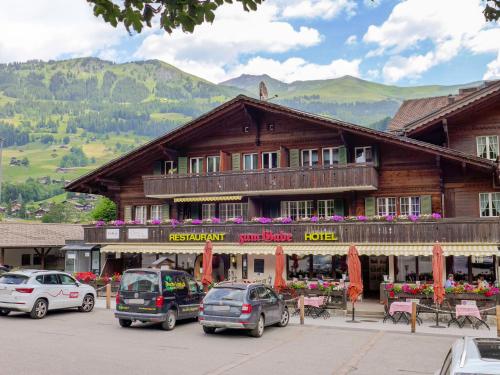 a large wooden building with cars parked in front of it at Apartment Gade A by Interhome in Lenk
