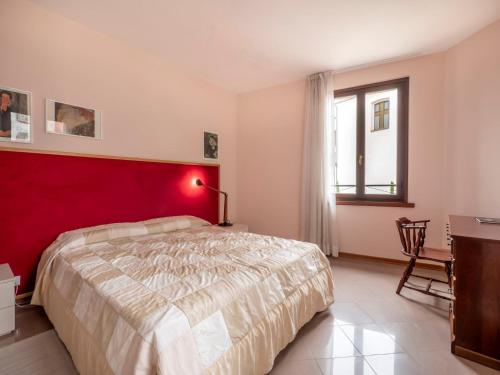 1 dormitorio con cama y pared roja en Apartment Squisleep-2 by Interhome en San Daniele del Friuli