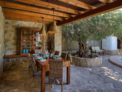 a wooden table and chairs in a patio with a tree at Holiday Home Mabrouk by Interhome in Jávea