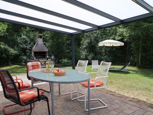 a patio with a table and chairs and an umbrella at Holiday Home Ferienwohnpark Silbersee by Interhome in Frielendorf