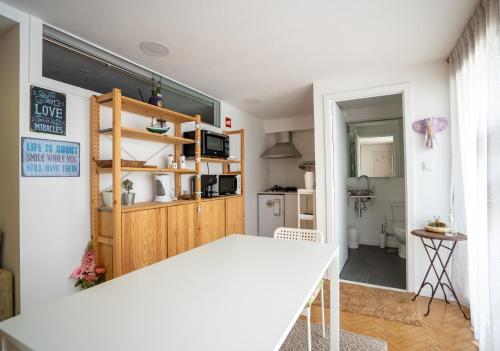 a kitchen and dining room with a white table in a room at Villa Amor Perfeito in Vila do Conde
