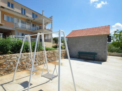 a pair of swings in front of a building at Apartment Miro-1 by Interhome in Grebaštica