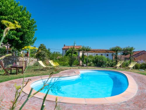 een zwembad in een tuin met stoelen en een huis bij Holiday Home Mariscotti by Interhome in SantʼAndrea