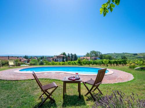 duas cadeiras e uma mesa em frente a uma piscina em Holiday Home Mariscotti by Interhome em SantʼAndrea