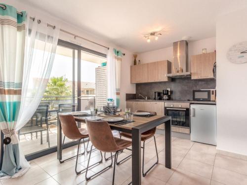 cocina con mesa y sillas y ventana grande en Apartment Le Clos des Alberes-1 by Interhome, en Argelès-sur-Mer