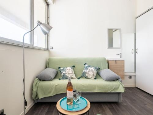 - un salon avec un canapé et une bouteille de vin sur une table dans l'établissement Studio Chéops-2 by Interhome, à La Grande Motte