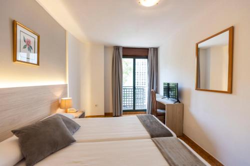 a hotel room with a bed and a mirror at Hotel Madrid in Pontevedra