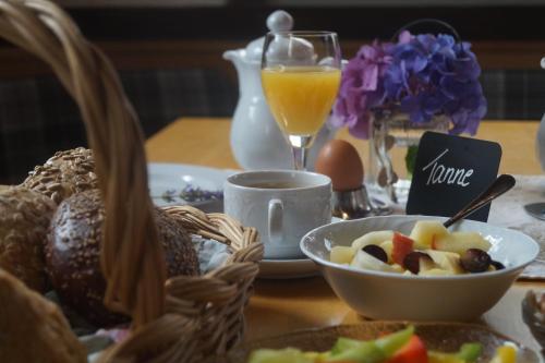 a table with a basket of food and a glass of orange juice at Naturhotel Holzwurm in Sasbachwalden