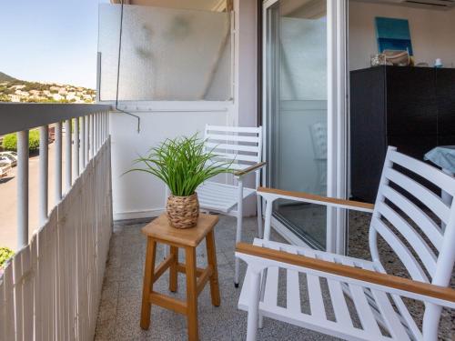 a porch with chairs and a potted plant on it at Apartment Le Carthage by Interhome in Carqueiranne