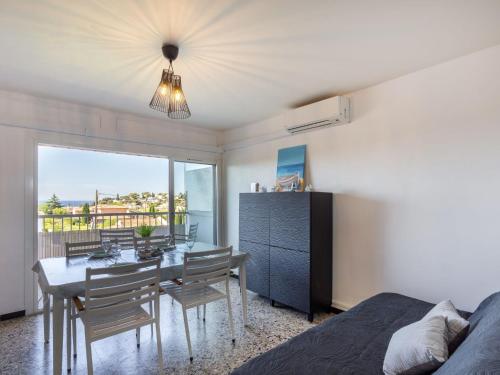 a bedroom with a dining room with a table and chairs at Apartment Le Carthage by Interhome in Carqueiranne