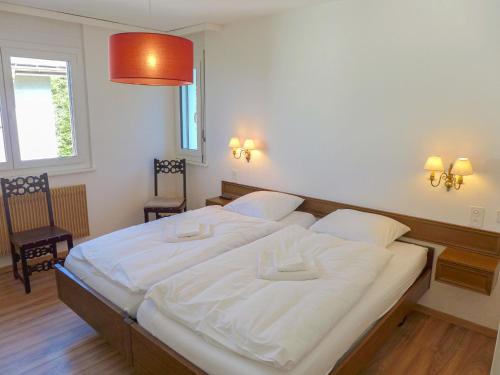 een groot wit bed in een kamer met 2 stoelen bij Apartment La Clairière des Barzettes A-B-7 by Interhome in Vermala