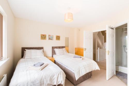 two beds in a small room with white walls at Great 4 bed house in Black Country in Tipton