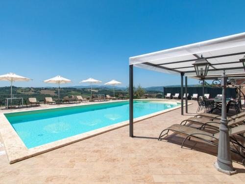 a swimming pool with chairs and umbrellas on a resort at Villa Futura by Interhome in Lorgnano