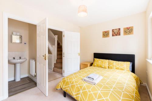 a bedroom with a bed and a sink and a staircase at Great 4 bed house in Black Country in Tipton