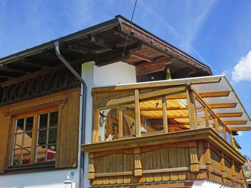 a wooden house with a balcony withwindows at Apartment Berghaus Waldner by Interhome in Reith bei Seefeld