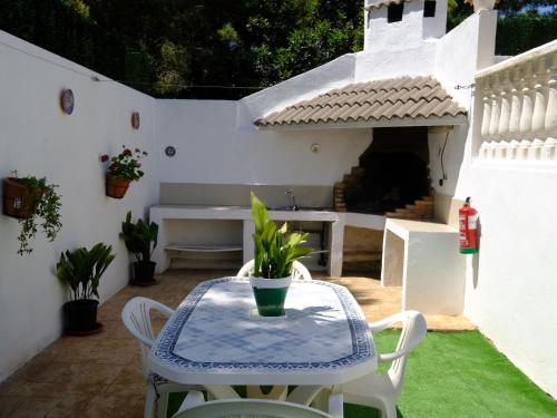 um pátio com uma mesa e cadeiras e um banco em Villa Uno by Interhome em L'Ametlla de Mar